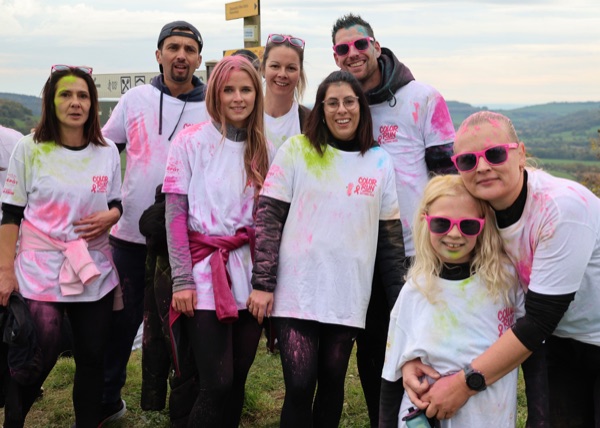 Photo de groupe de participants à la Color Run, tee-shirts blancs couverts de poudre colorée