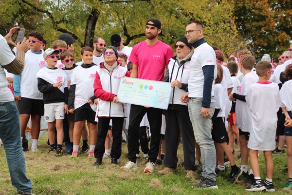 Remise d'un chèque de dons à l'association ADPS, entourée de jeunes participants de la Color Run
